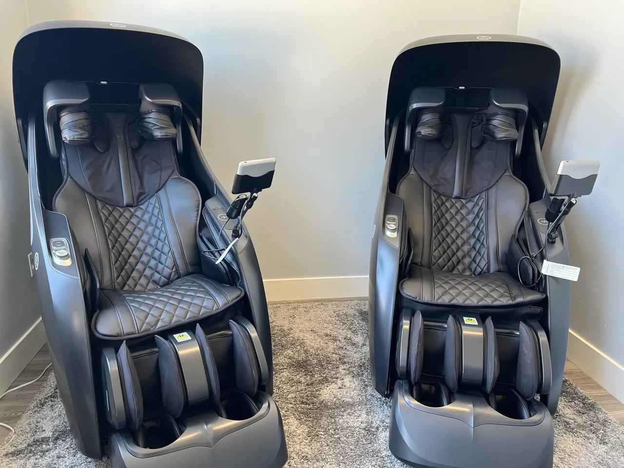 Two black massage chairs side by side