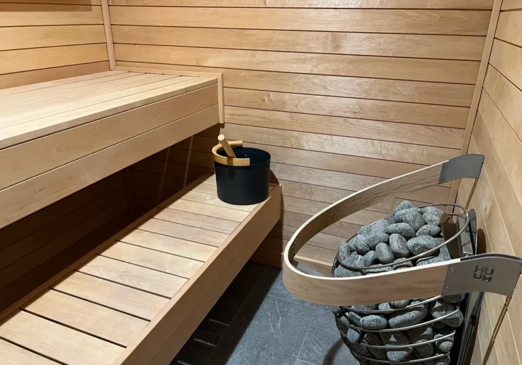 Wooden sauna interior with heater and bucket